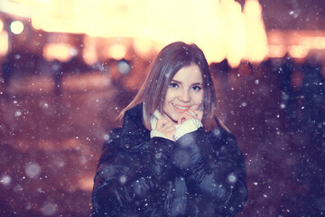 Fototapeta na wymiar snowfall woman city christmas outside, city portrait in snowfall, young model posing in festive look