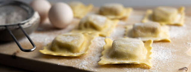 Homemade tortellini made with organic ingredients on a dark stone table . Top view.
