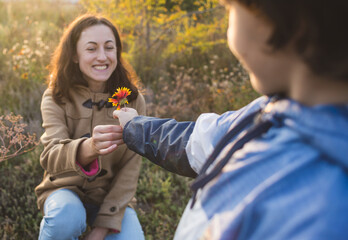 Obraz premium A child gives a flower to his mother