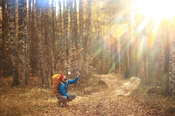 autumn hike with a backpack, sun rays, autumn landscape, a man in the forest glare of light sunset