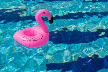 Summer concept background. Pink inflatable flamingo in pool water for summer beach background. Pool float party.