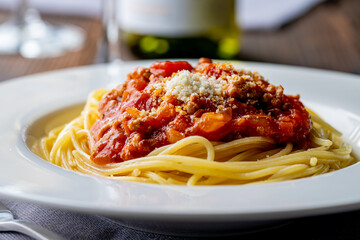 Pasta with meat and tomato sauce on wooden table.
Italian food concept.
