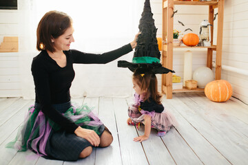 Happy family of mother and children prepare for Halloween in decorate the home