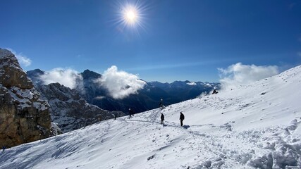 Two people trekking across snowy mountain landscape - 386351165