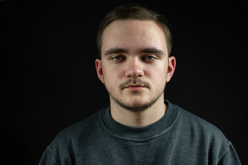 guy in dark clothes portrait on black background young man adult looking at the camera