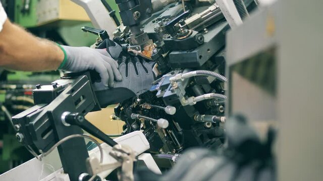 Shoemaker using a machine to shape a shoe. Shoemaking industry concept.