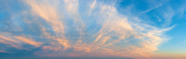 Majestic vanilla sky at evening. Azure sunset heaven with golden pink cirrus clouds over the...