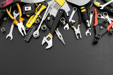 Many different tools for repair work on a black background with copy space for text.