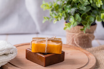 Two bars of soap and a towel on a wooden platter.