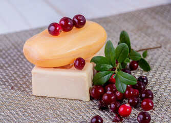 Two bars of soap and cranberries on the table. spa procedures.