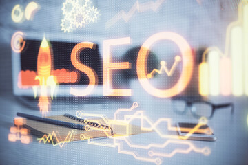 Multi exposure of table with computer and seo drawing hologram. Search optimization concept.