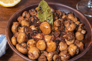 Vegan mushroom fricassee with garlic on a rustic background close-up - mushrooms with garlic, French cuisine.