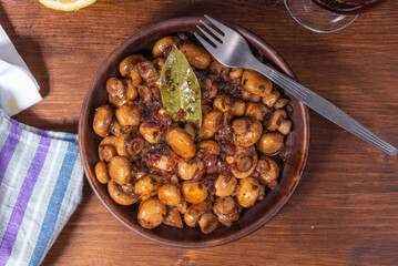 Vegan mushroom fricassee with garlic on a rustic background close-up, top view - mushrooms with garlic, French cuisine.