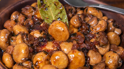 Vegan mushroom fricassee with garlic on a rustic background close-up - mushrooms with garlic, French cuisine.