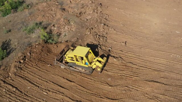 Earthworks Dozer (Bulldozer) Excavator in mountainous terrain, land correction and field clearing