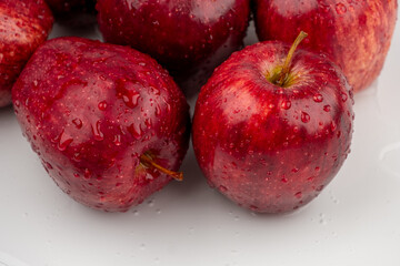Pile of red apple with clear water drop on shell surface texture pattern isolated, white background