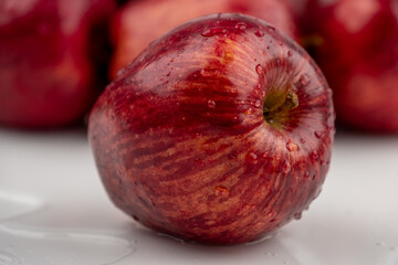 Close up of pile of red apple with clear water drop on 
shell surface texture pattern isolated, white background