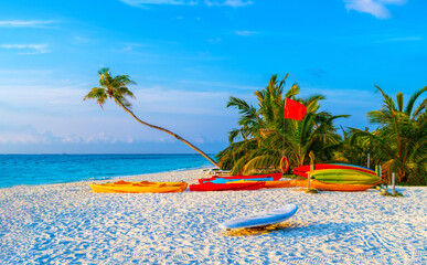 Boats for water activities in the Maldives lie on the shore in the sand. The concept of water sports, tourism.