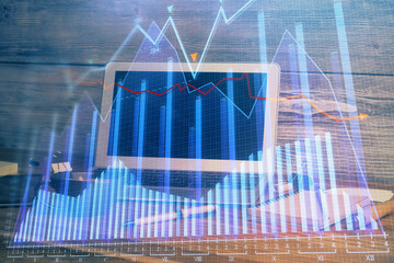 Double exposure of graph and financial info and work space with computer background. Concept of international online trading.