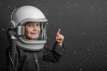 A small child imagines himself to be an astronaut in an astronaut's helmet. © vovan
