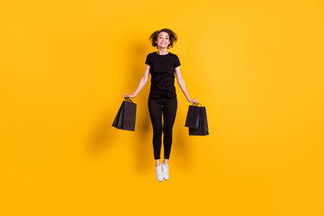 Full length body size view of attractive cheerful funky girl jumping carrying packages bargain...