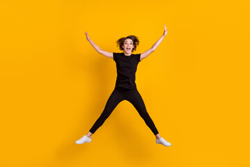 Fototapeta na wymiar Full length body size view of skinny funky cheerful girl jumping having fun free time isolated bright yellow color background