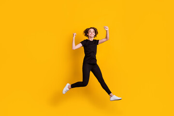Fototapeta na wymiar Full length body size view of slender lucky cheerful girl jumping having fun rejoicing isolated bright yellow color background