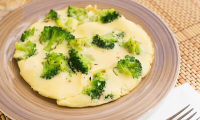 wholesome breakfast. omelet with broccoli on brown plate