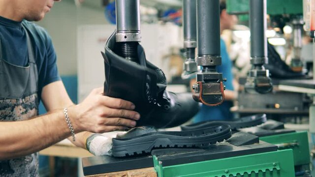Bootmaker marking a shoe sole line using a pen