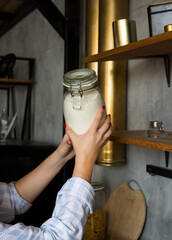 female hands holding a jar of flour