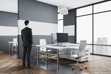 Businessman standing in loft style coworking office