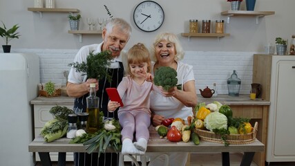 Blogger girl making selfie on phone with senior couple grandparents at kitchen with vegetables