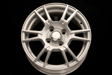New silver alloy wheel on black background, front view