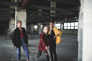 Attack of teenage girls thugs in abandoned building, gang violence and bullying concept.