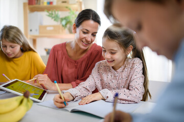 Group of homeschooling children with teacher studying indoors, coronavirus concept.