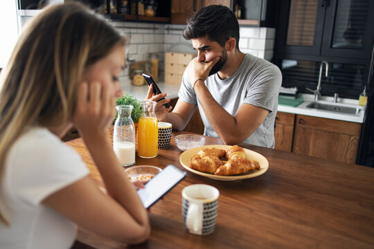 Unhappy couple sitting in the kitchen