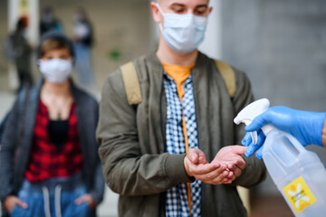 Young students back at college or university, coronavirus and disinfecting hands concept.