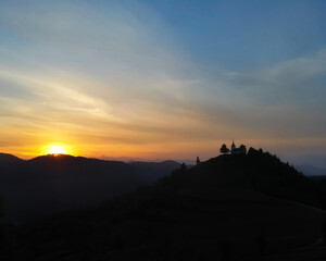 sunset over the mountains and church