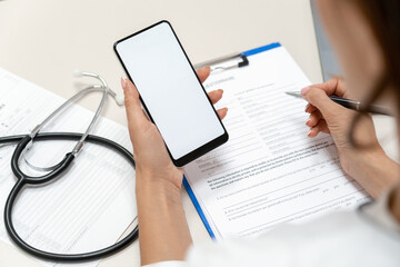 Mockup on mobile phone holding by female doctor.