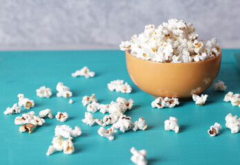 full plate of popcorn, movie concept, close up of popcorn in bowl of salted popcorn at the old wooden table. Dark background. selective focus