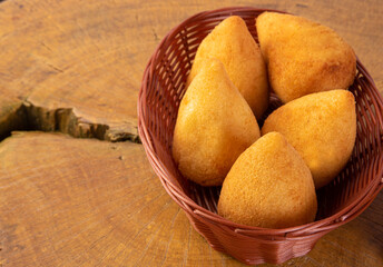 Croquette stuffed with chicken, drumstick, on wooden surface, gray background, selective focus.