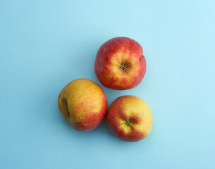 Red ripe round apples lie on a blue background