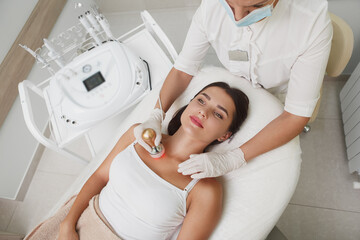 Top view shot of a woman enjoying rf-lifting skincare treatment by beautician
