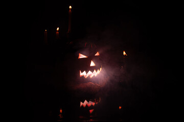 Jack pumpkin head from Brazil made with watermelon, candles, low key portrait, horror portrait, red flash and a lot of smoke in the scene. Selective focus.