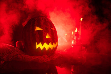 Jack pumpkin head from Brazil made with watermelon, low key portrait, horror portrait, red flash and a lot of smoke in the scene. Selective focus.