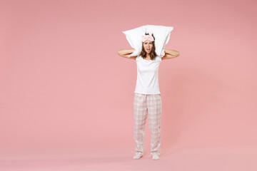 Full length portrait of angry irritated young woman in pajamas home wear sleep mask hold pillow...