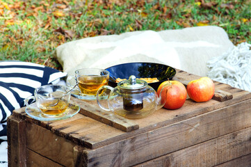 Аutumn picnic on a wooden cassette with tea, gofretes and apples 