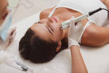 Woman getting rf-lifting facial by professional cosmetician