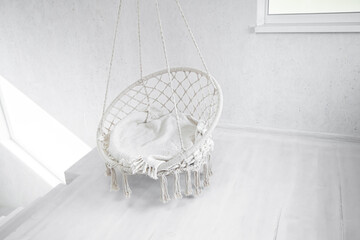 Fototapeta na wymiar Hygge scene with white hammock chair on white background. Cozy place for weekend relax in the room.