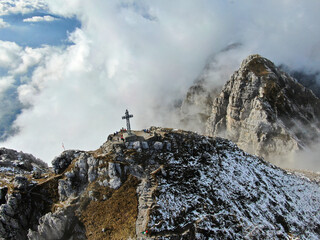 Fototapeta premium The mountain peak of Mount Resegone next to Lecco, surrounded by clouds on a cold autumn day
